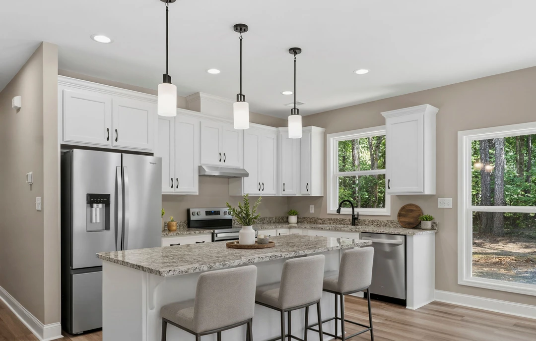 Kitchen with a large central island featuring granite countertops, white cabinetry, stainless steel refrigerator with water dispenser, chairs along the island, a plant in a white