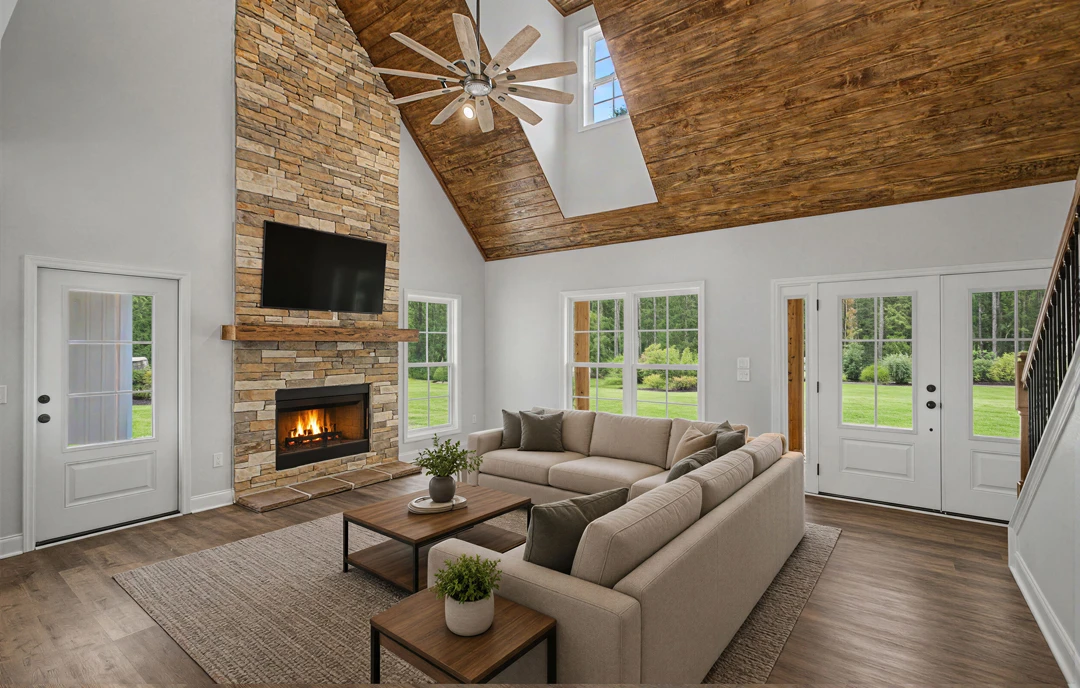 Living room with a brick fireplace, gray couch, wood flooring, coffee table with a potted plant, and ceiling fan.