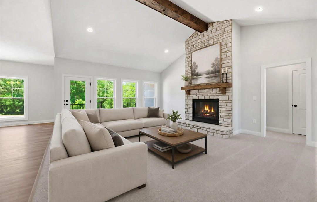 Living room with a brick fireplace, fire burning inside, two couches, a coffee table with a basket, a painting of trees above the hearth, and a wall of square windows.