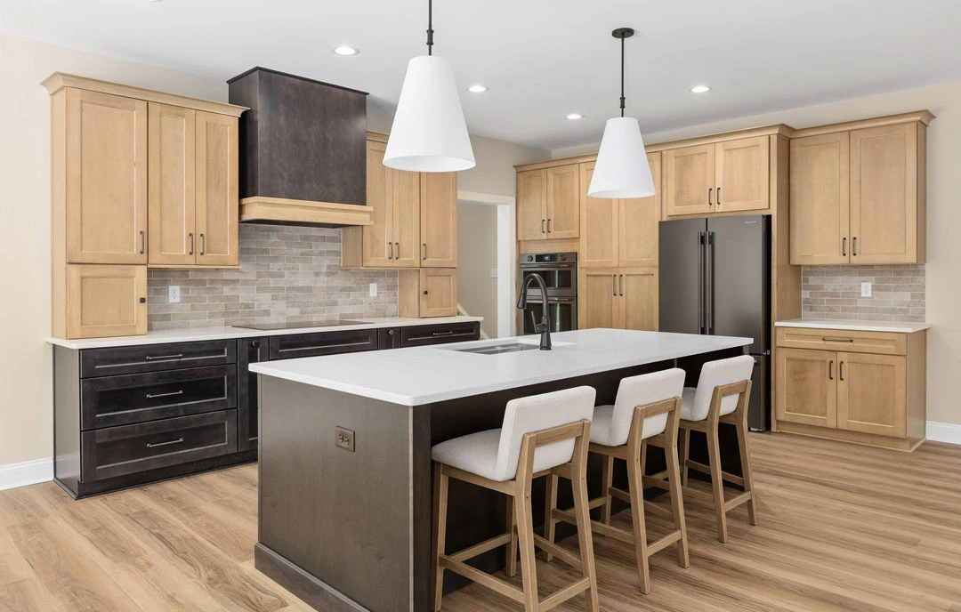Kitchen with a large central island featuring white stools with wooden legs, granite countertops, white cabinetry, stainless steel appliances including an oven and microwave, and
