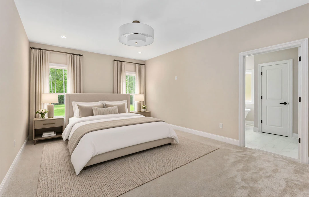 Bedroom with a bed featuring white sheets and a brown blanket, a freestanding bathtub, white door with black handles, and a white light fixture.
