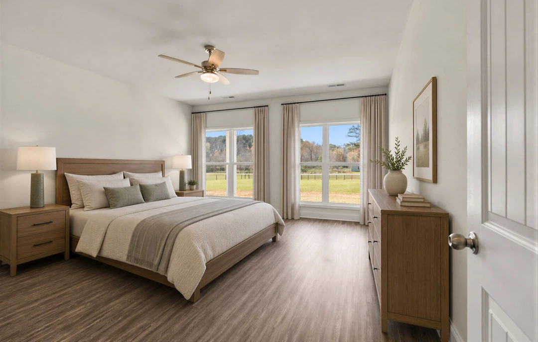 Bedroom with a large bed featuring a wood headboard, white bedding, and pillows, a ceiling fan with a light overhead, a dresser topped with a vase, a nightstand with a lamp, and a