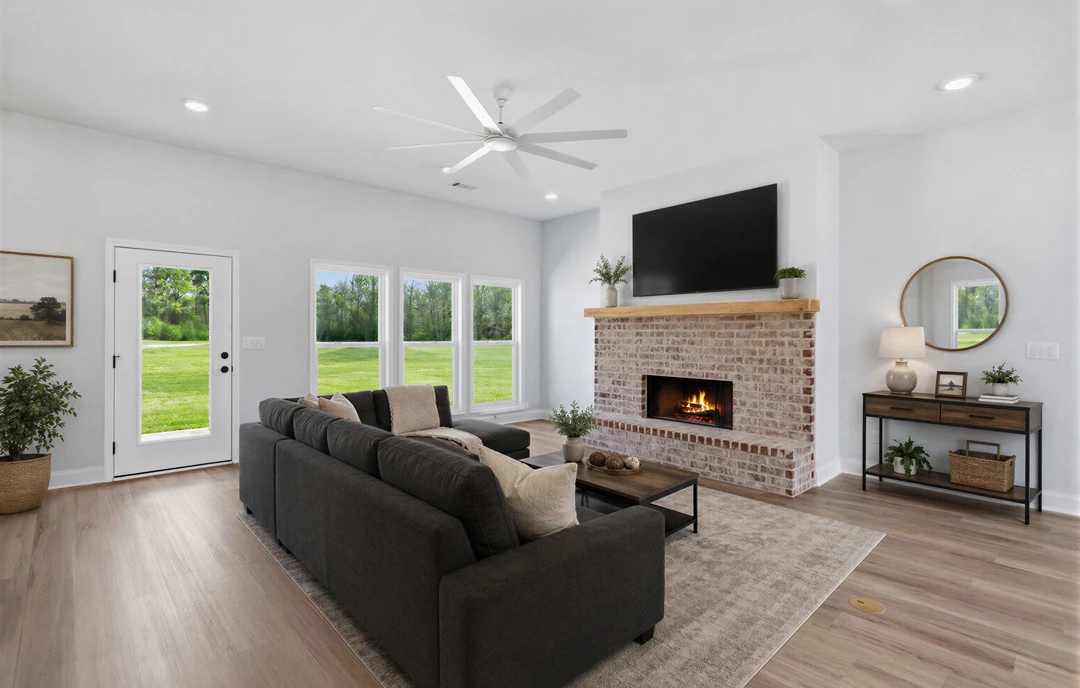 Living room with a fireplace, light-colored couch, wood laminate flooring, coffee table holding a basket and potted plant, and neutral walls.
