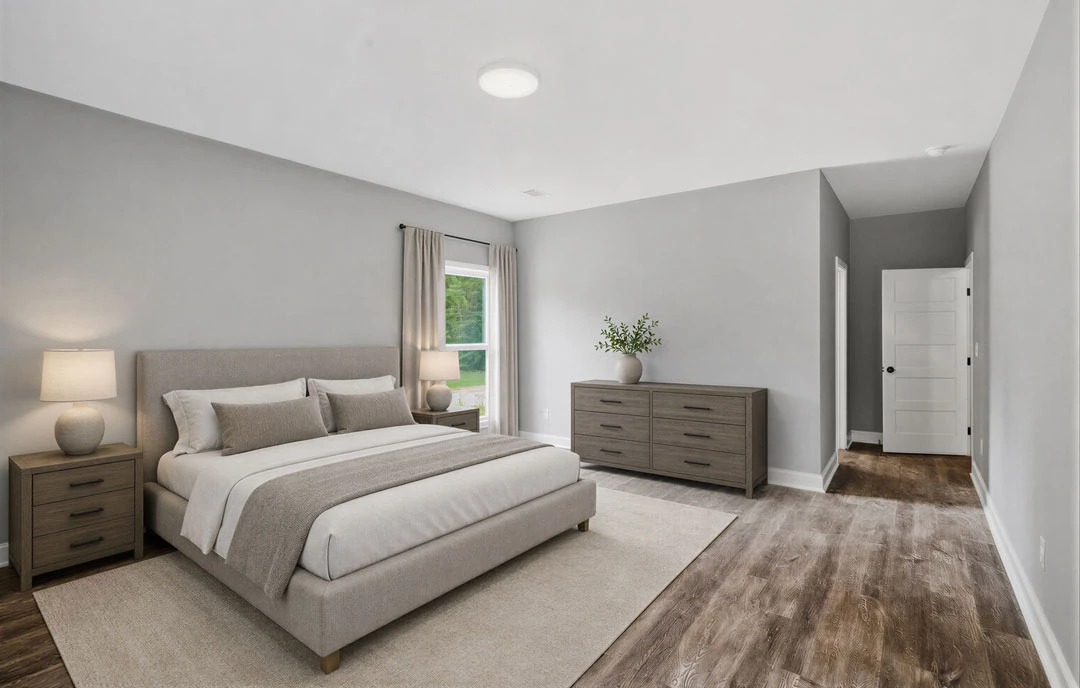 Bedroom with a bed featuring white bedding, a wooden dresser topped with a bowl and vase, a window with a white curtain and lamp, and a plant in a vase.
