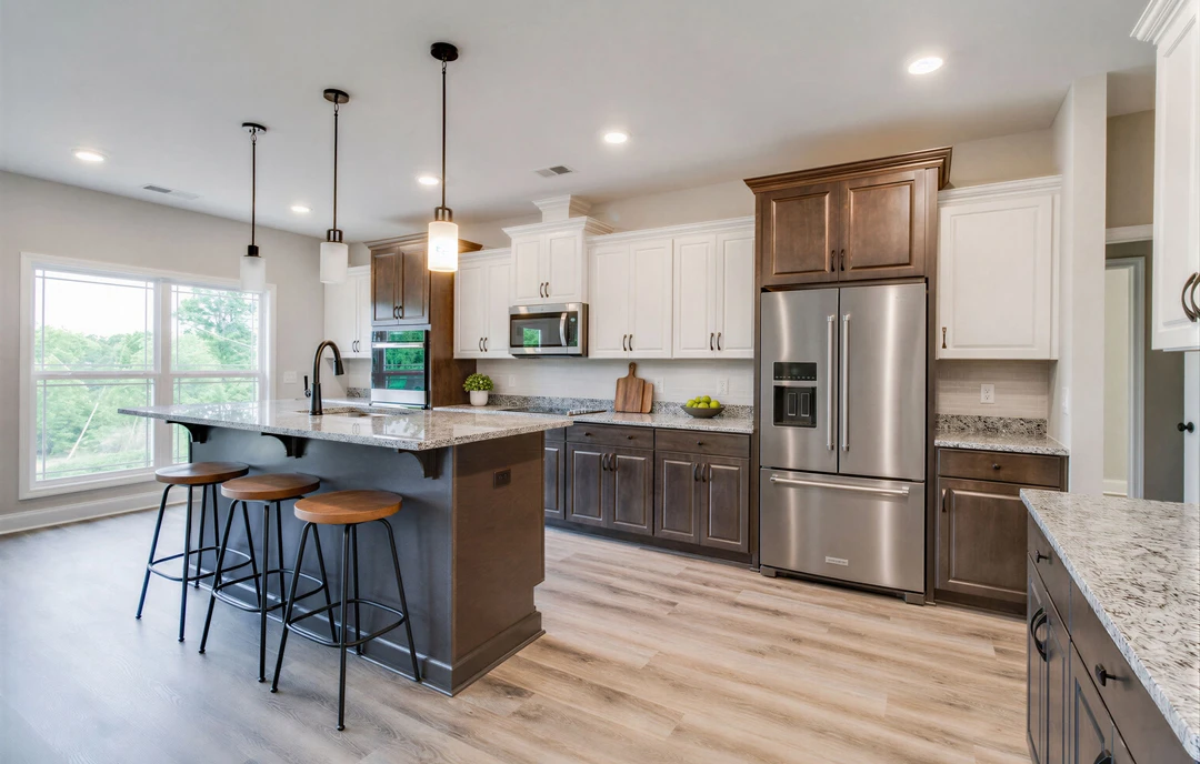 Kitchen with a large central island featuring granite countertops, white cabinetry, stainless steel refrigerator, built-in microwave, and black bar stools with white seats on wood