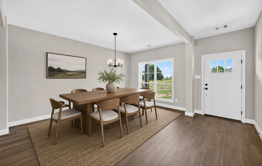 Dining room with a wooden table and chairs on hardwood flooring, a white door with a window, and a plant in a vase.