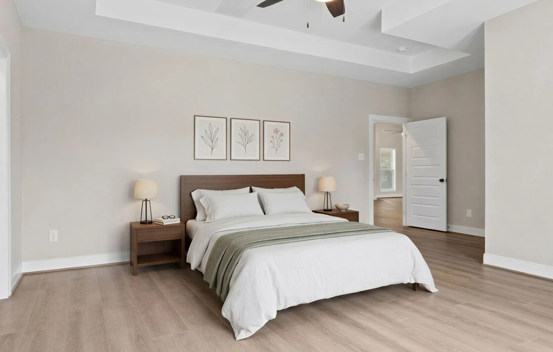 Bedroom with a bed featuring a wood headboard, white bedding, and pillows, a ceiling fan overhead, a nightstand with a lamp and glasses, framed pictures on the wall, and a white
