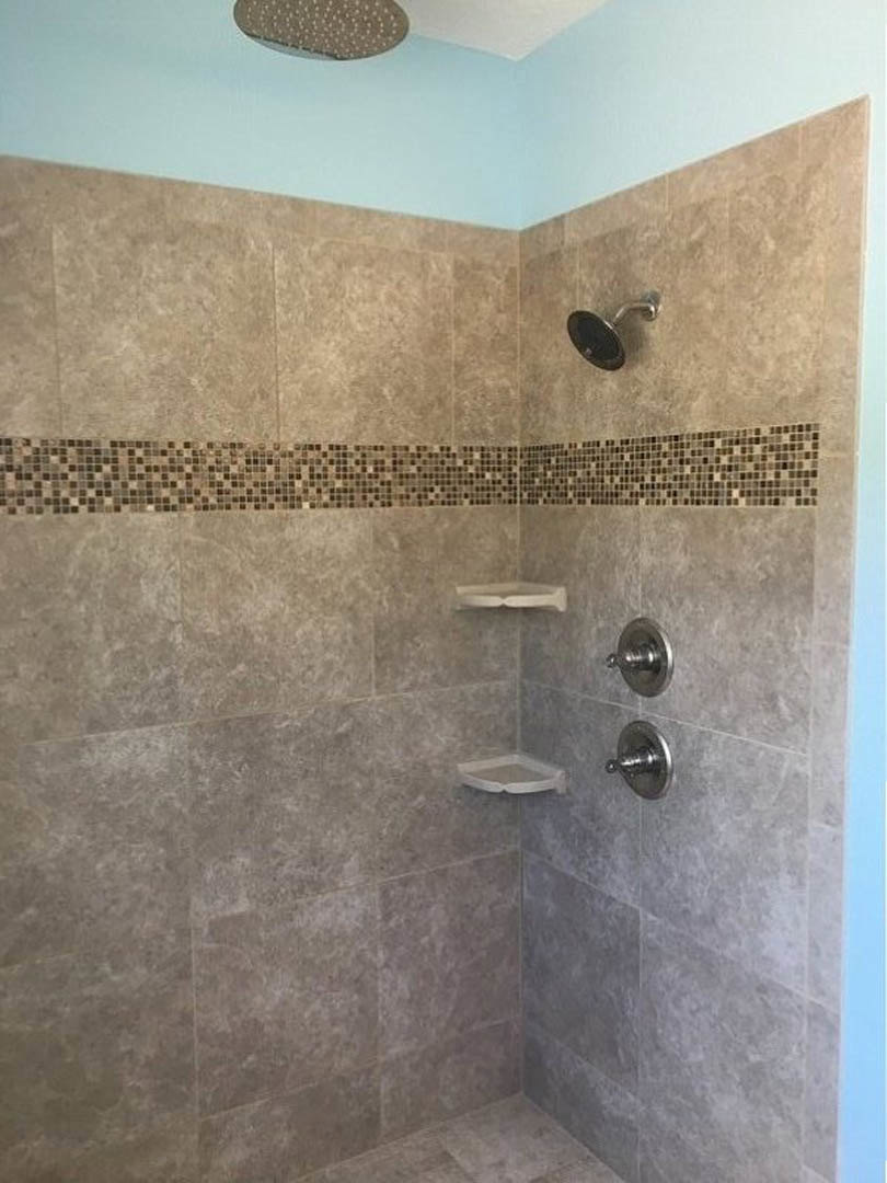 Marble-tiled shower with built-in shelves and chrome shower head