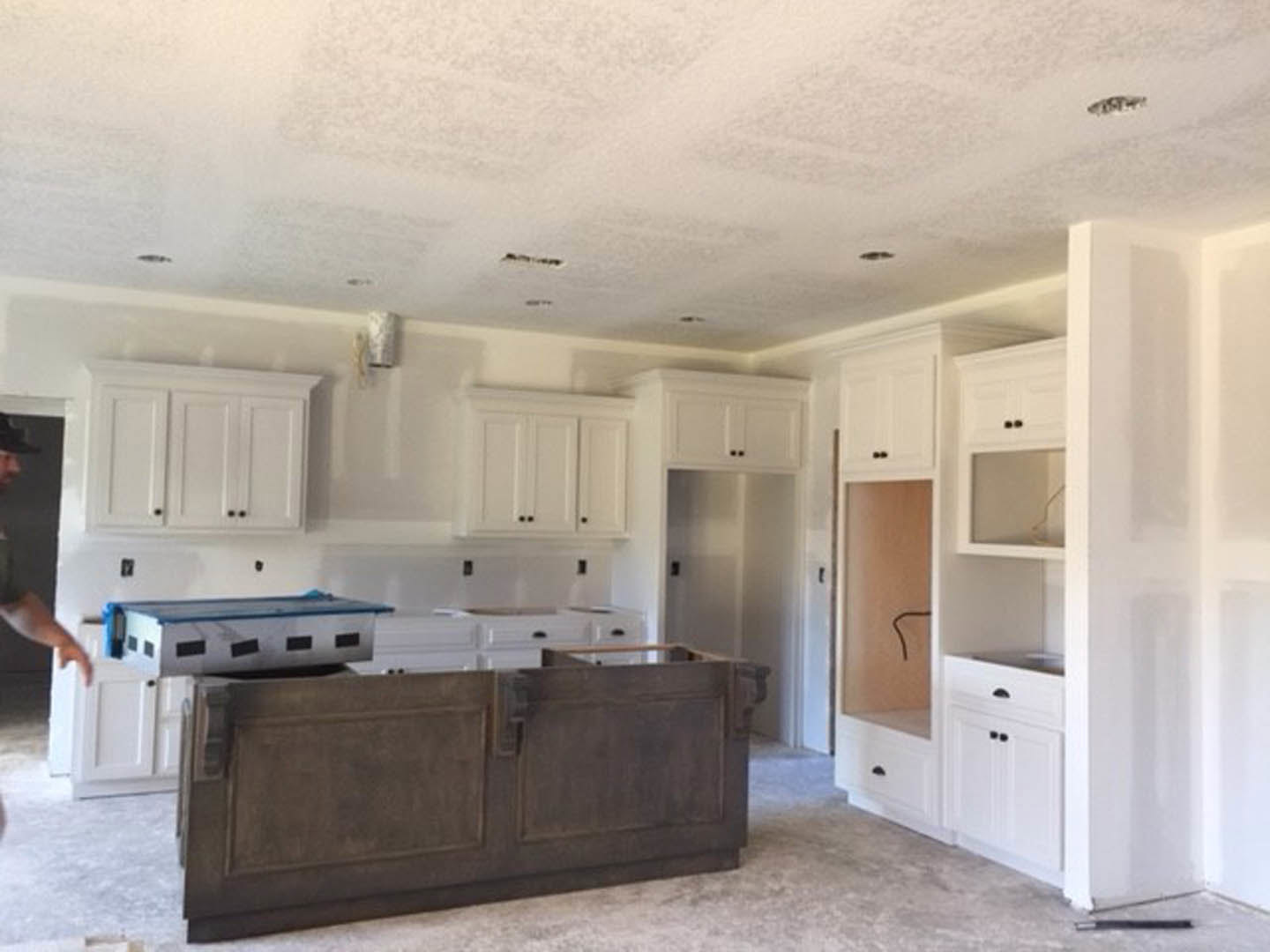 White kitchen cabinets with stainless steel appliances, light countertops, and a pool table in the open-plan space