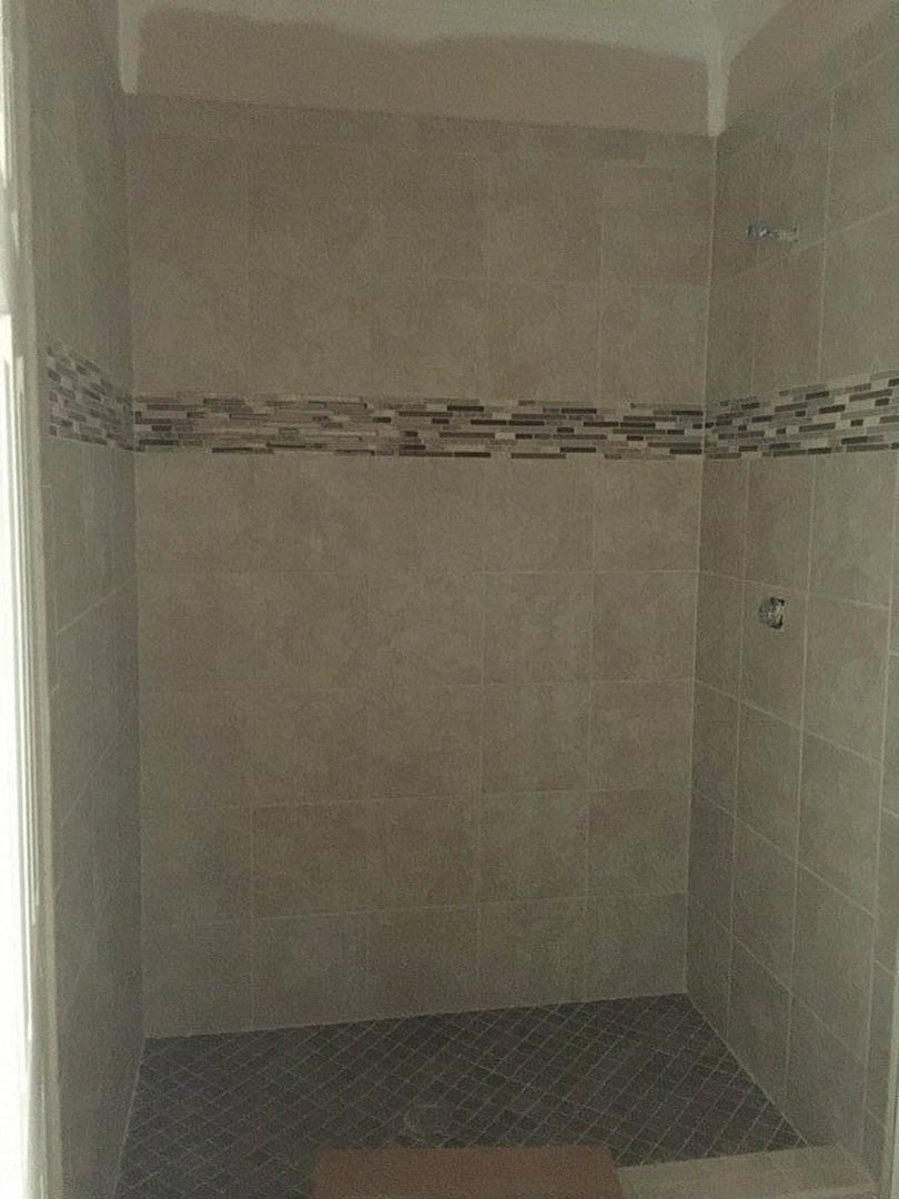 Brown tile shower walls with square grid pattern and matching tile floor