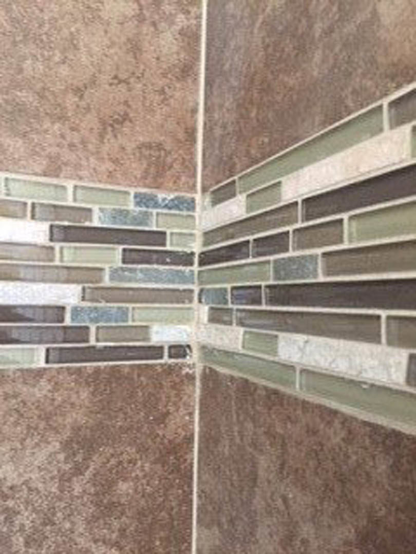 Close-up of a tile wall featuring various colored tiles in an indoor residential space