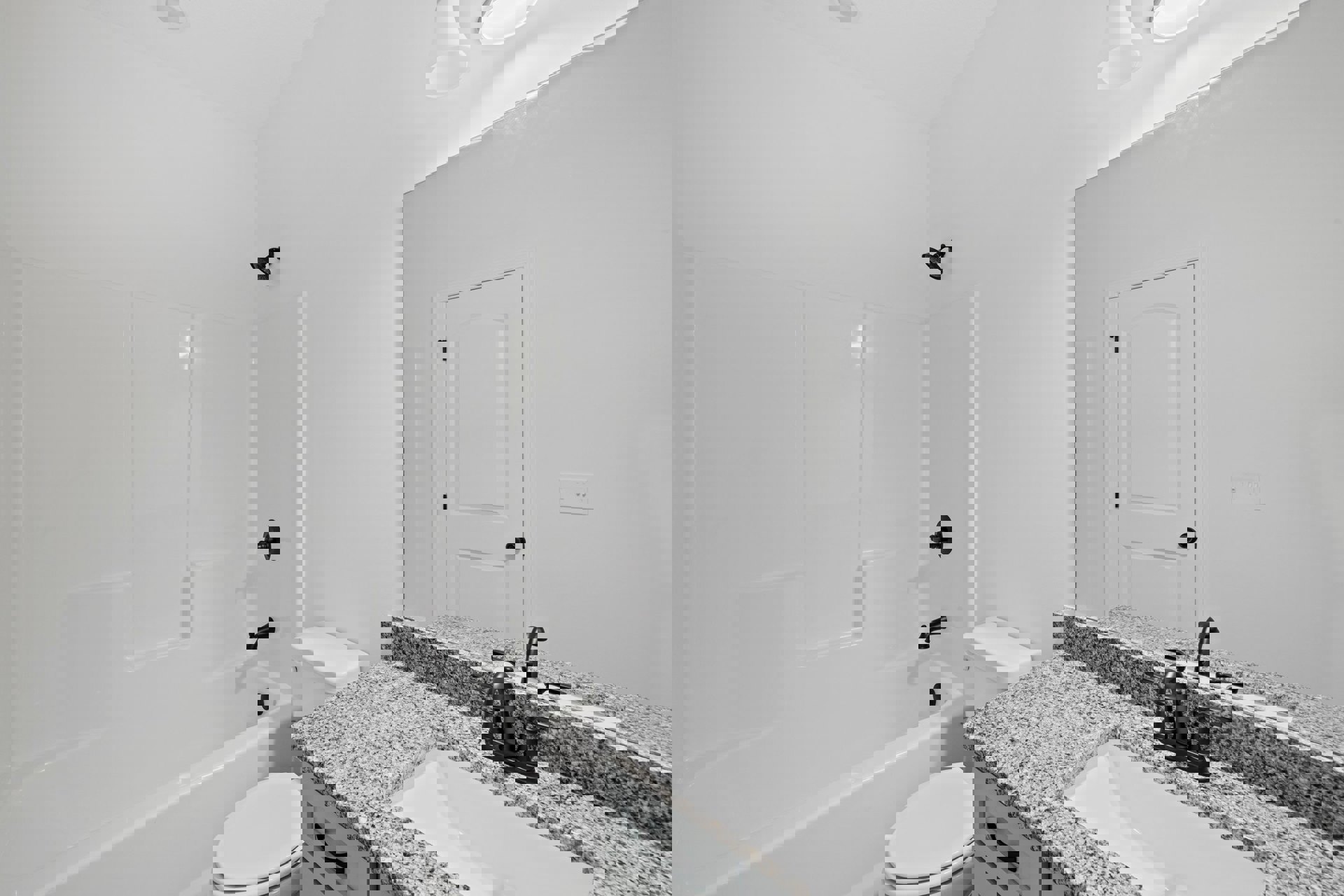 Modern bathroom with white porcelain sink, chrome faucet, white toilet, glass-enclosed shower, black showerhead, and light gray tile walls