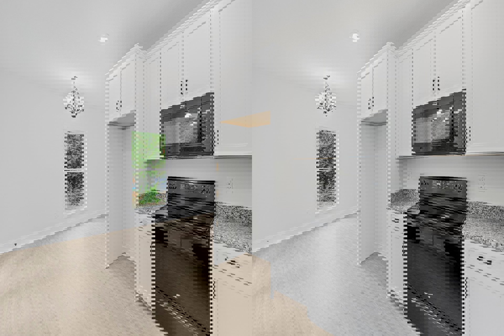 White kitchen cabinets, black stove and oven, black microwave with side light, five-light fixture, white ceiling light, window showing trees outside