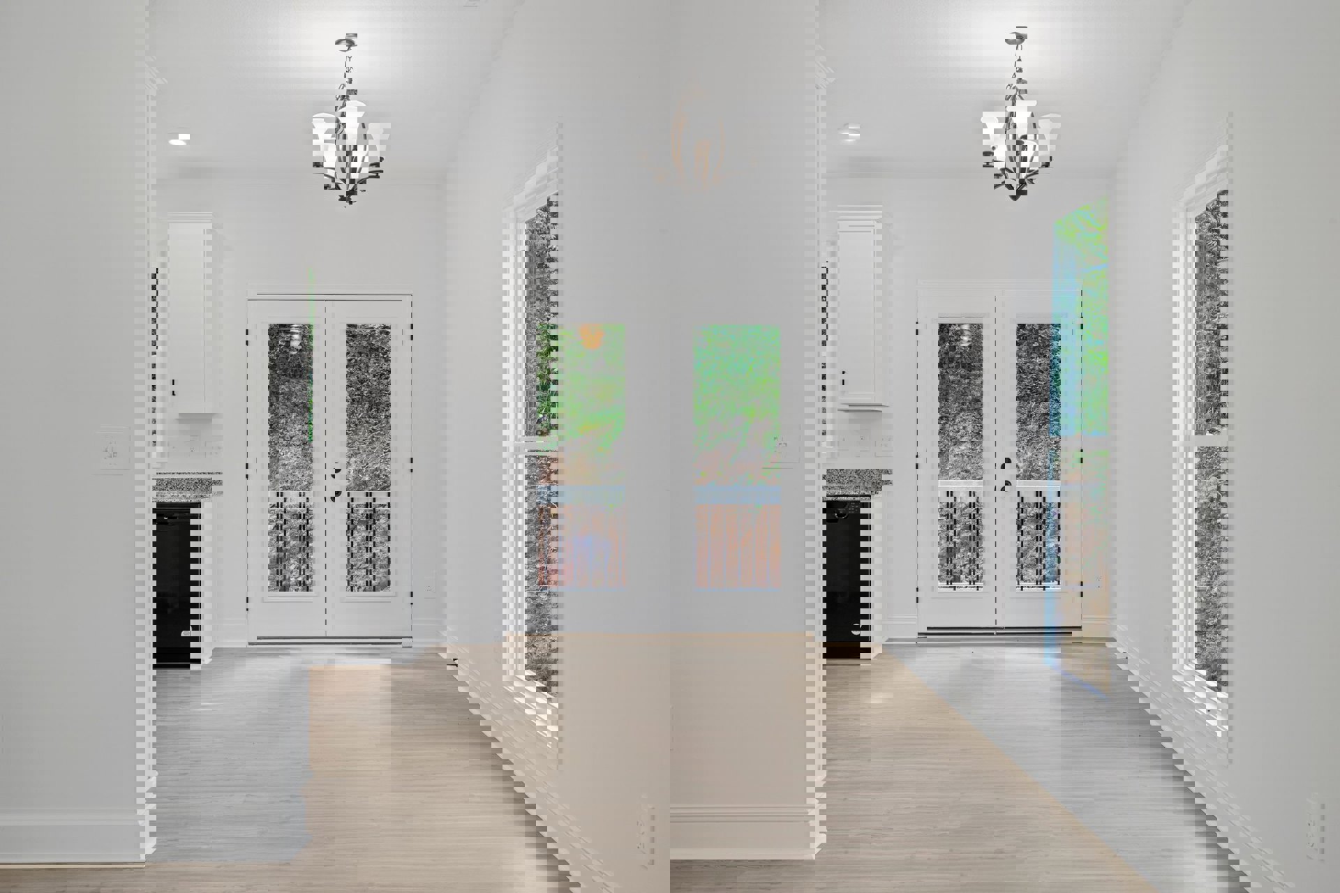 White walls and ceiling, wood plank flooring, double glass-paneled doors, chandelier with white shades, decorative molding along baseboards and door frames