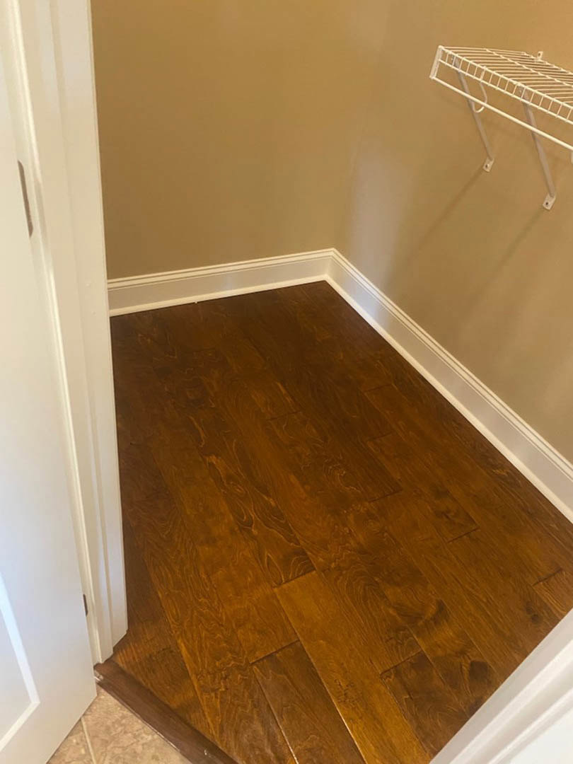 Hallway with light wood flooring and white metal wall-mounted racks