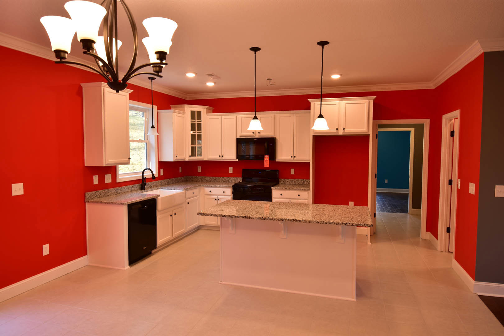 White kitchen cabinets with granite countertops, stainless steel sink, track lighting, and light-colored flooring
