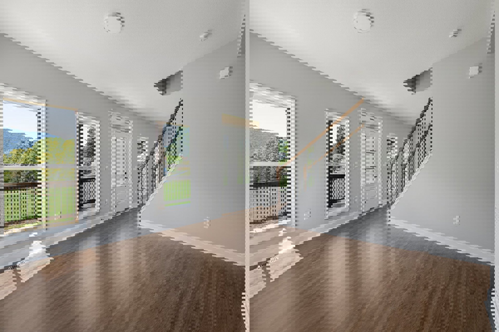 Hardwood floor room with white paneled door, glass-paned door, and wood staircase; white walls, ceiling molding, and window view of balcony.