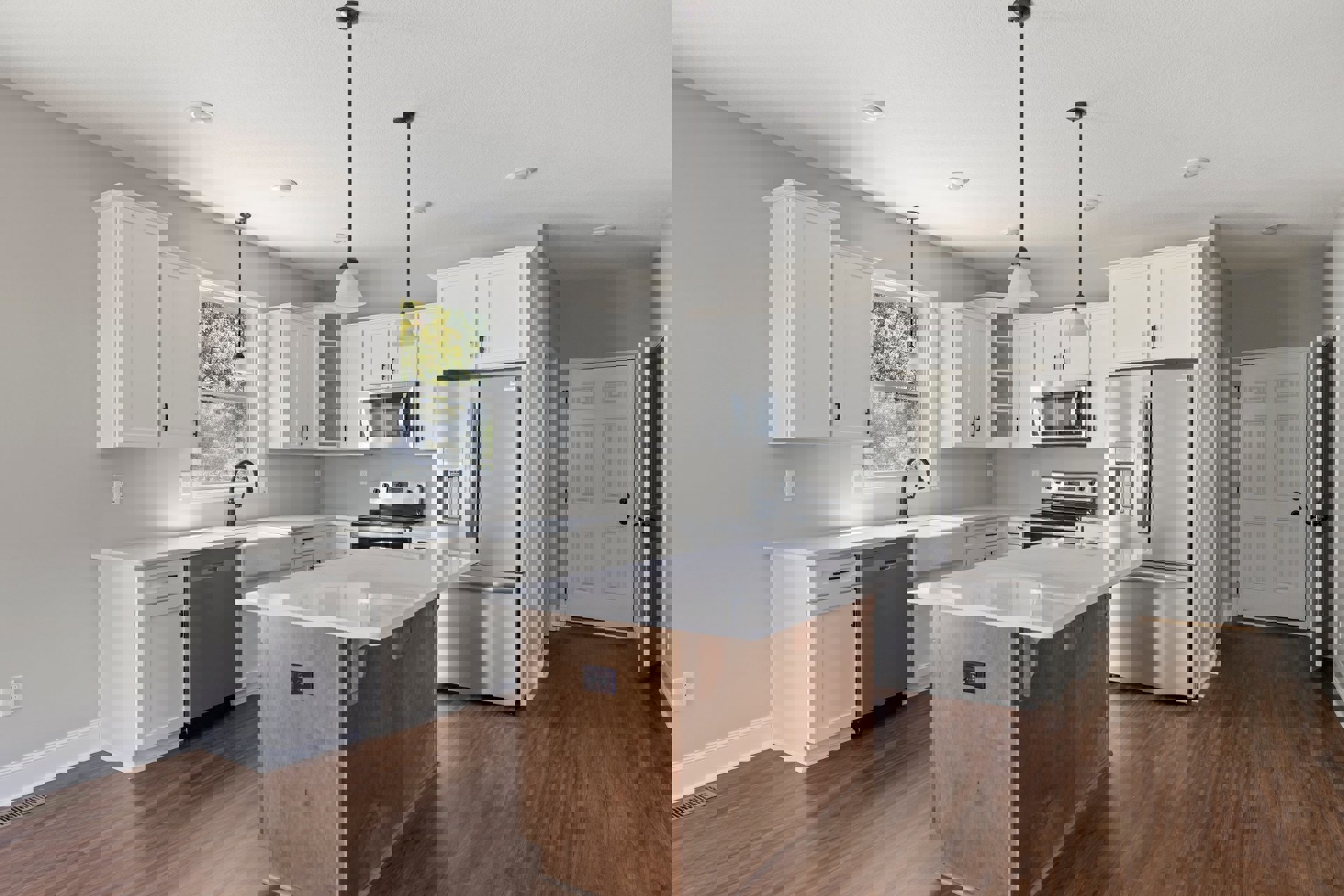 Spacious kitchen featuring a large island with white countertop, stainless steel refrigerator with ice and water dispenser, microwave oven, white cabinetry with black knobs, black