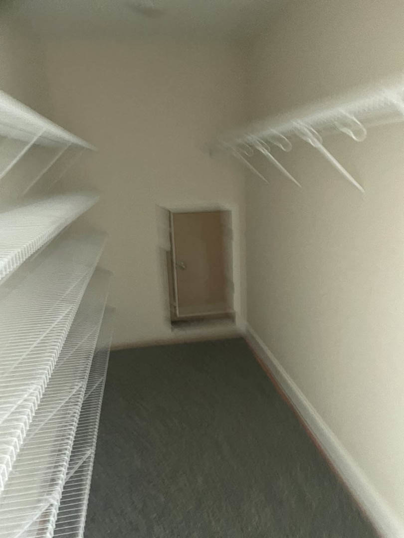 White bathroom with built-in wall shelves, plaster walls, light flooring, and a closed white door