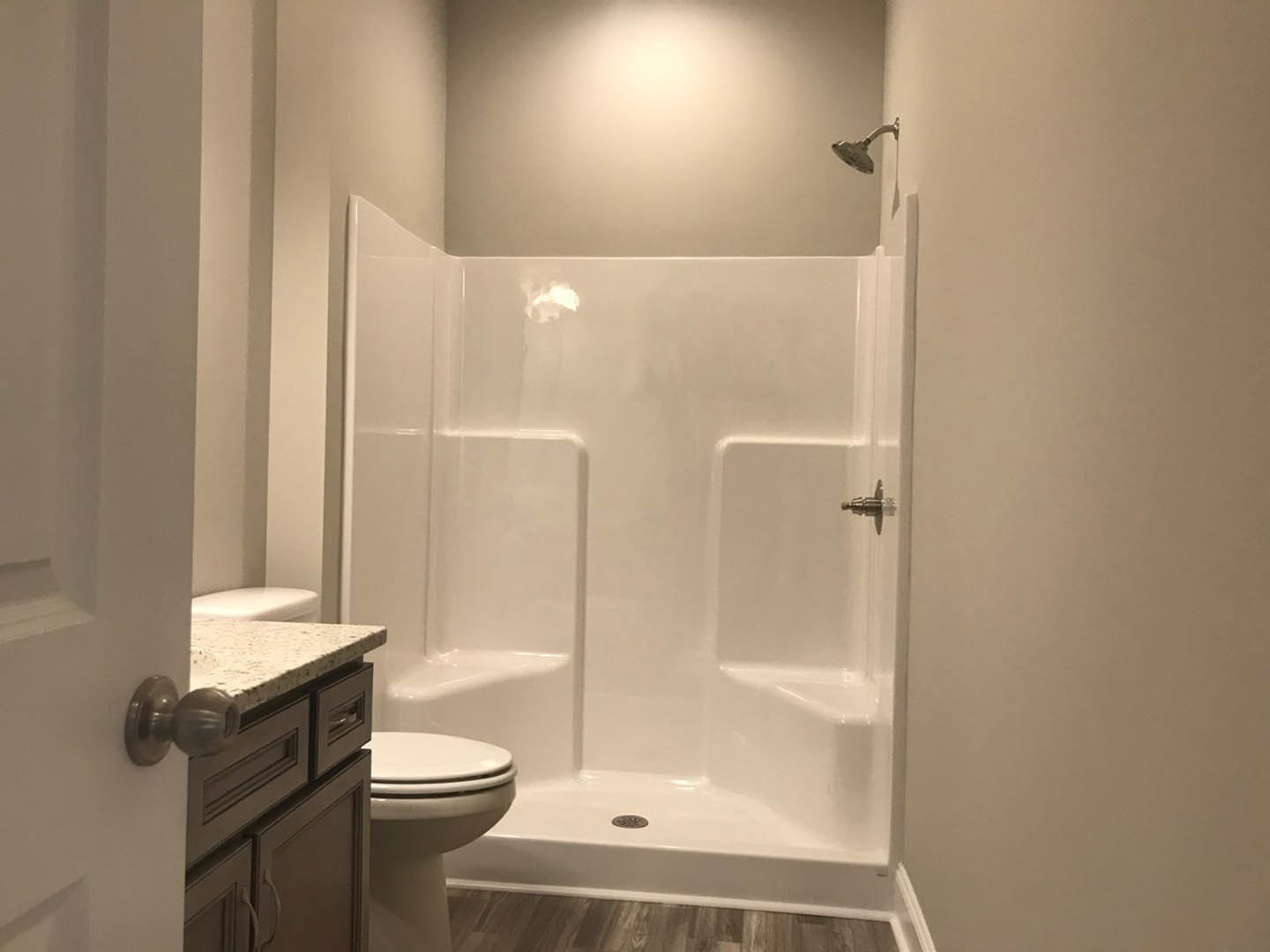Modern bathroom with glass-enclosed shower, white tile walls, wall-mounted toilet, and chrome fixtures