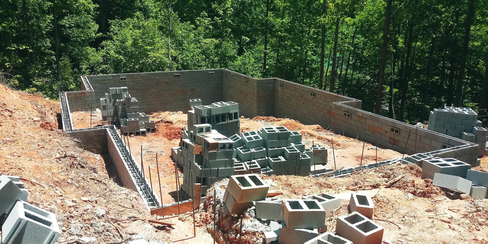 Cement blocks stacked on a construction site with trees in the background