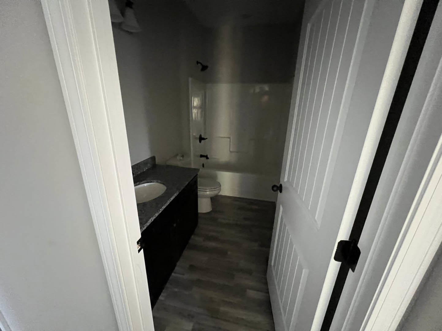 Modern bathroom with white ceramic sink, matching toilet, light gray tile flooring, and white plaster walls