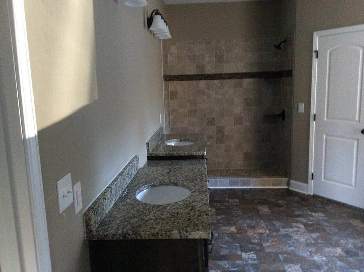 Bathroom featuring marble countertops, undermount sink, chrome faucet, tiled walls, and modern bathroom accessories