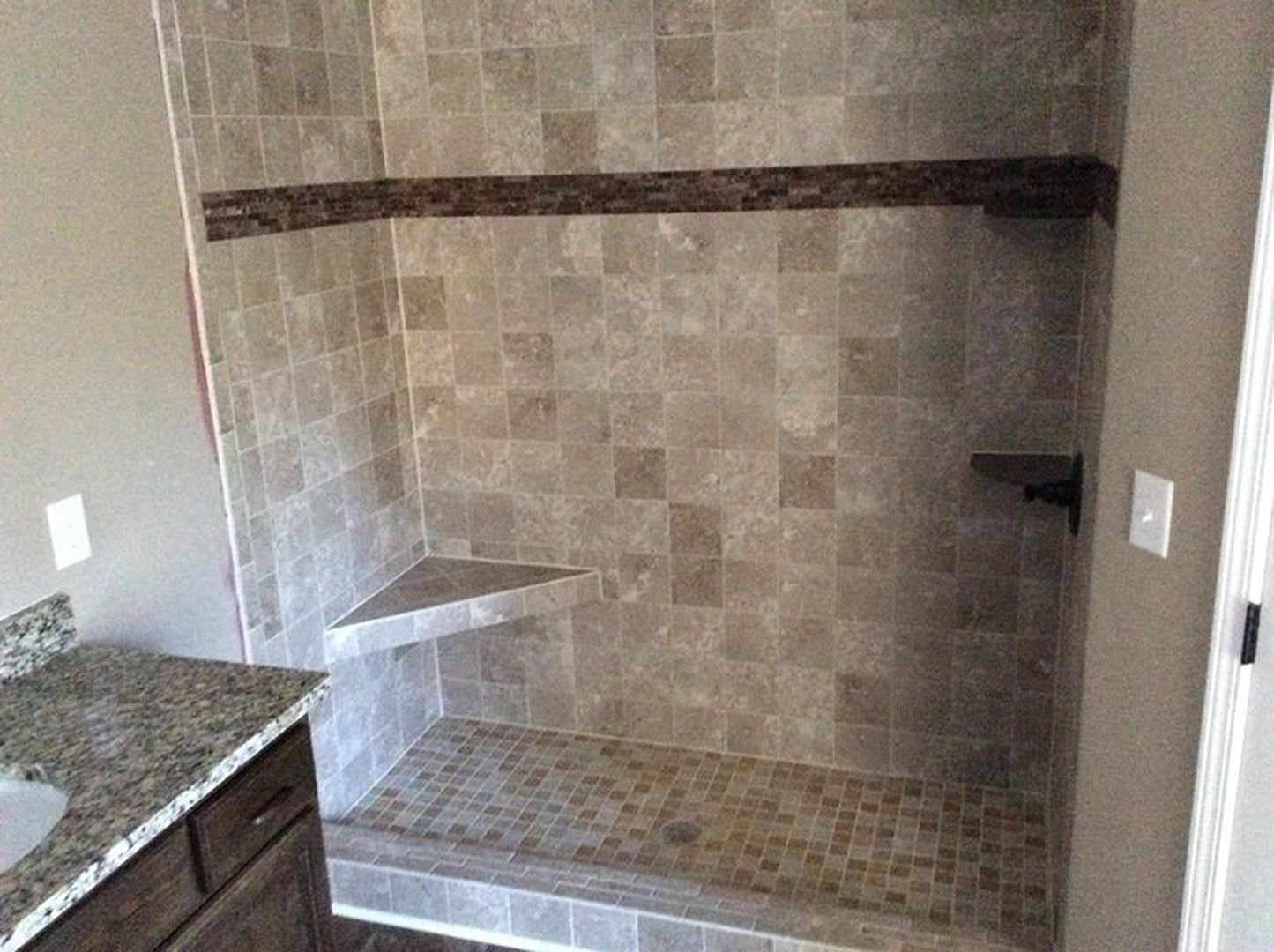Bathroom with glass-enclosed shower, marble countertop vanity, chrome fixtures, white rectangular sink, tile flooring, and neutral wall finishes
