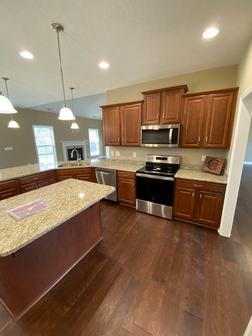 Granite countertop kitchen with stainless steel stove, white cabinetry, built-in microwave, and undermount sink