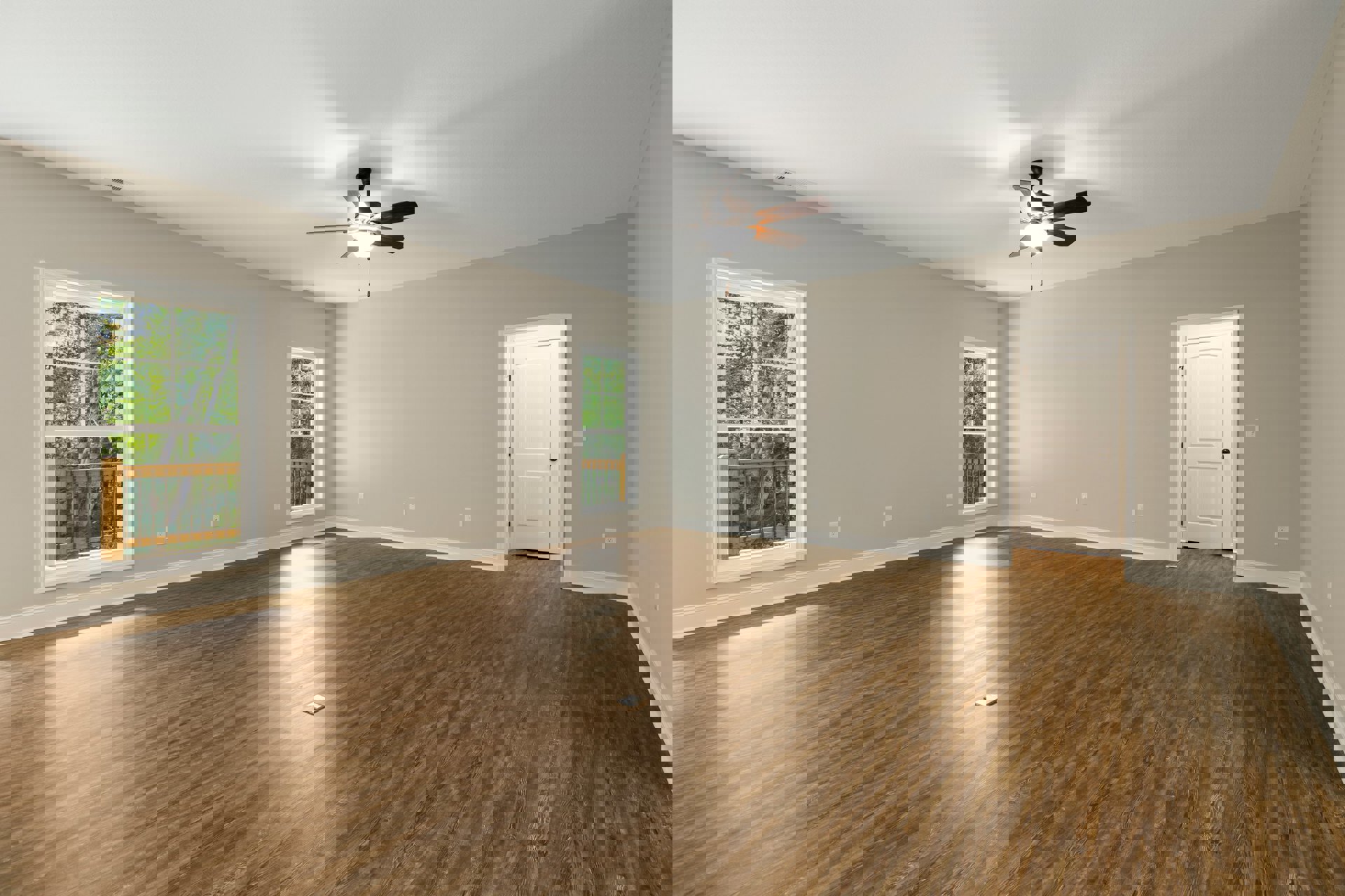 Room with hardwood flooring, white walls, ceiling fan with light, white-framed window showing trees outside, and white door with black knobs