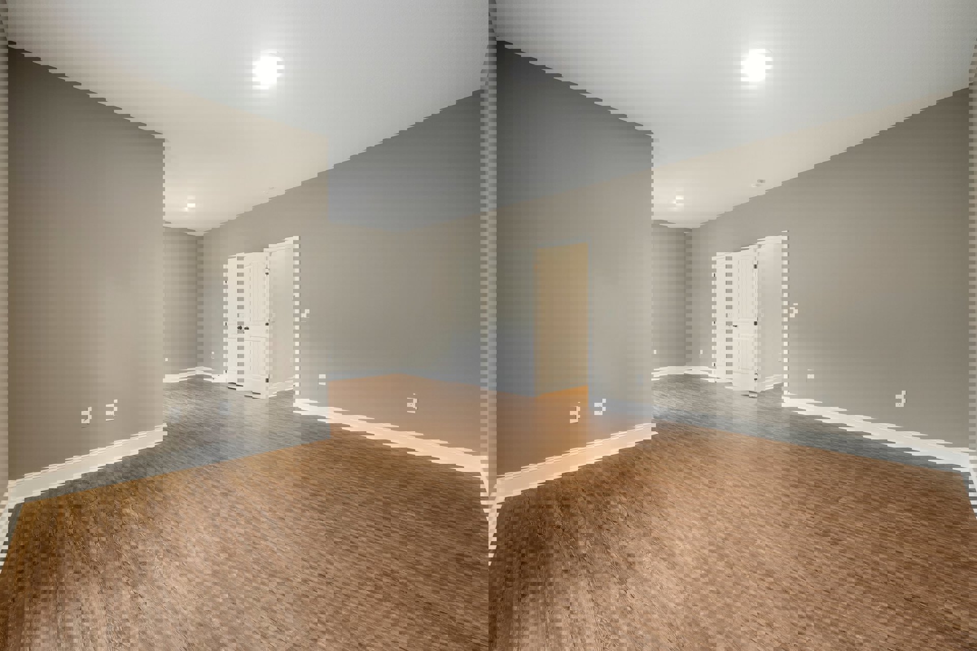 Hardwood floor room with white paneled doors featuring black knobs, white walls, and a ceiling light fixture