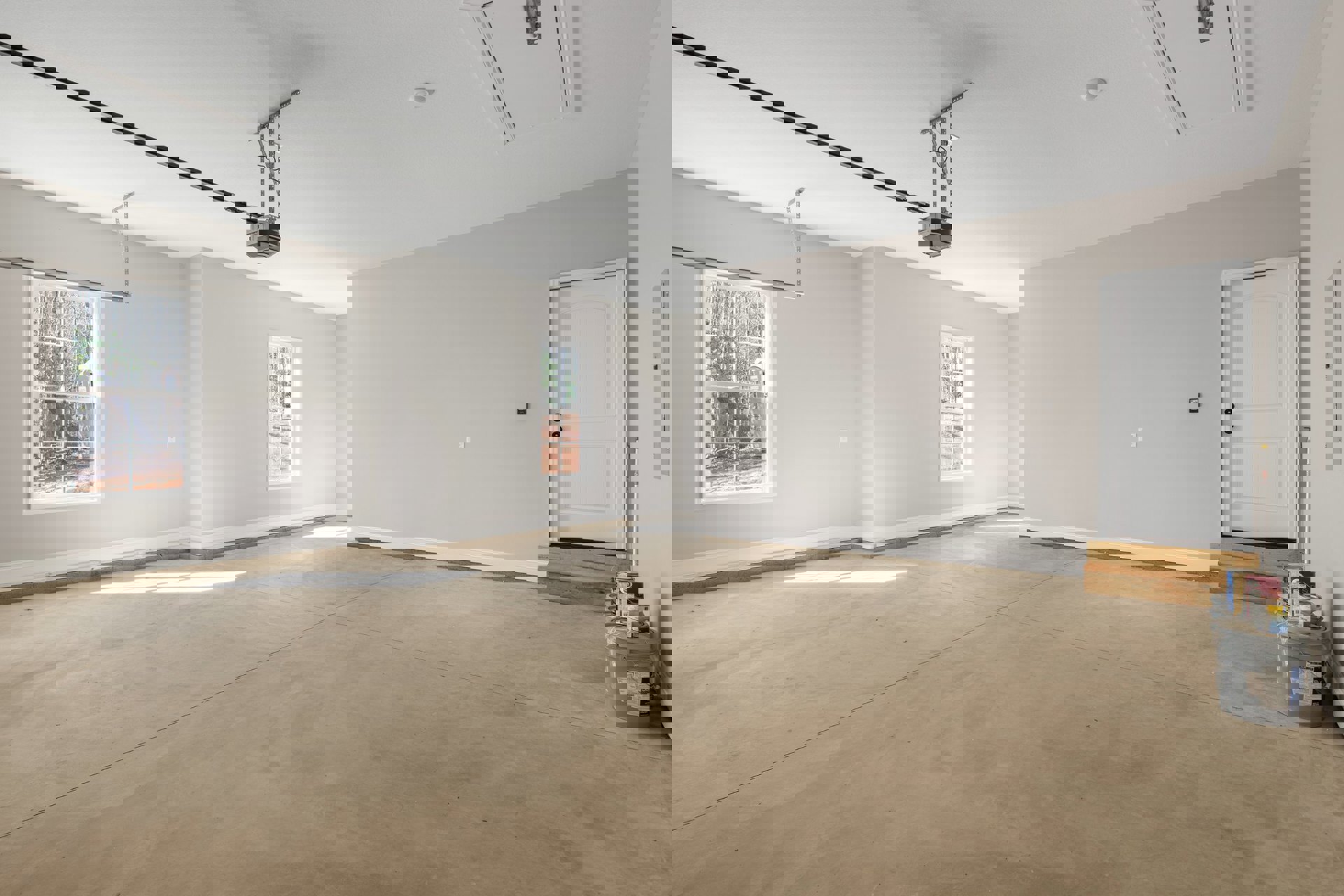 White door with black knobs, tile floor, large window overlooking forest, paint bucket near wall, plaster walls and ceiling