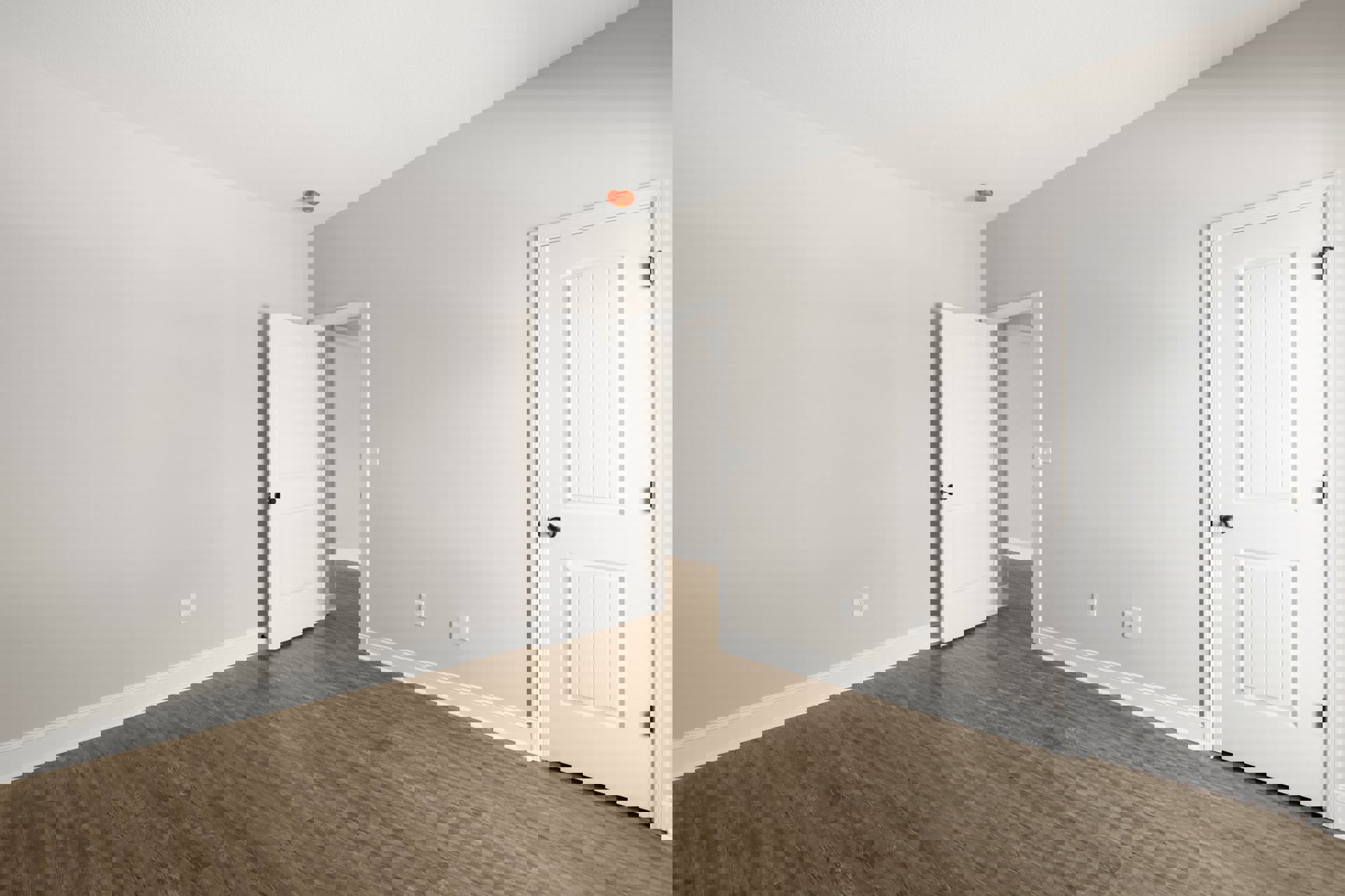 White walls and ceiling, white door with black knob, wood laminate flooring