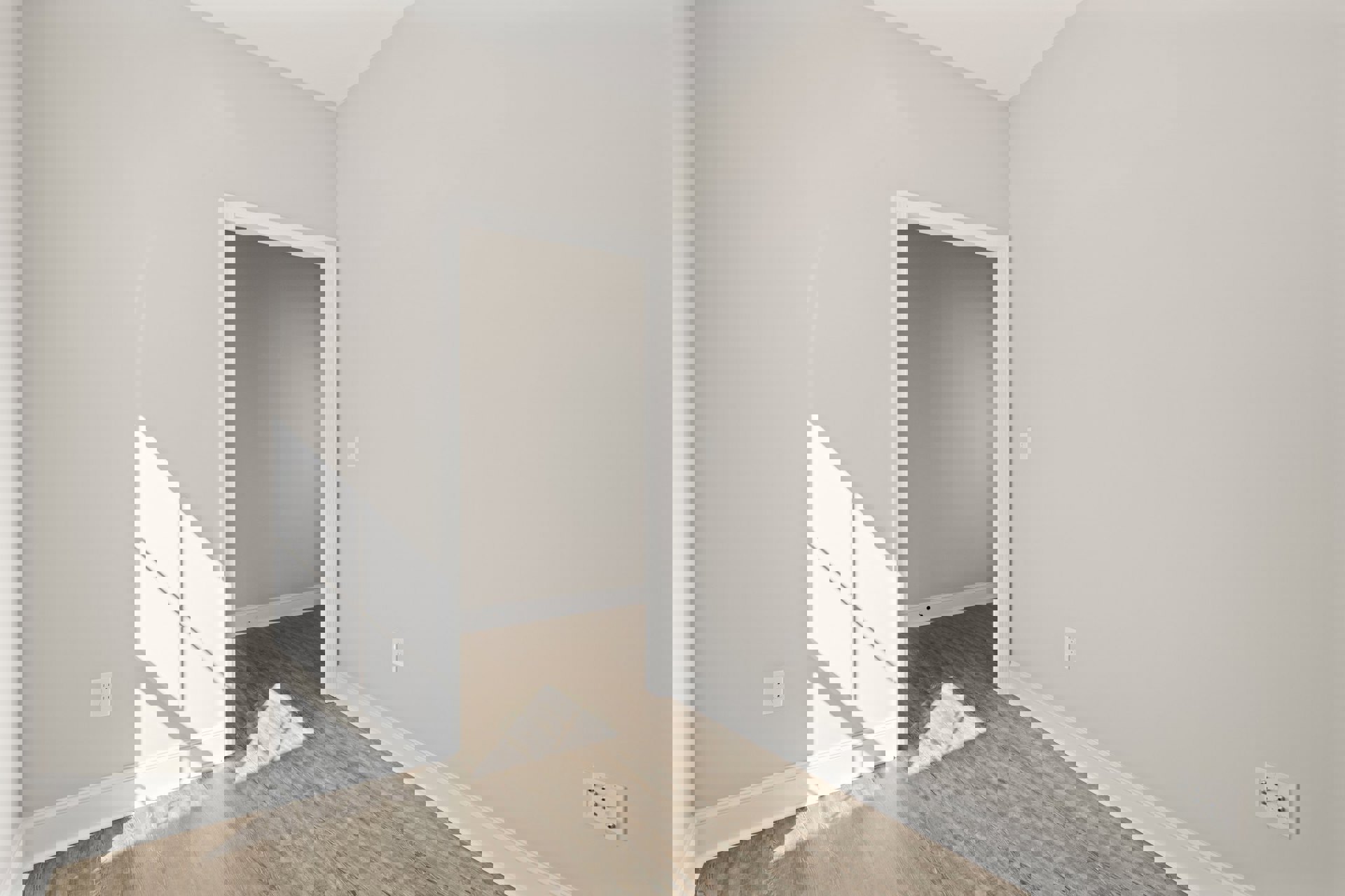 Open door reveals room with white walls, multiple socket outlet, grey accent wall, laminate flooring, white ceiling with corner molding, and floor lamp casting shadow.