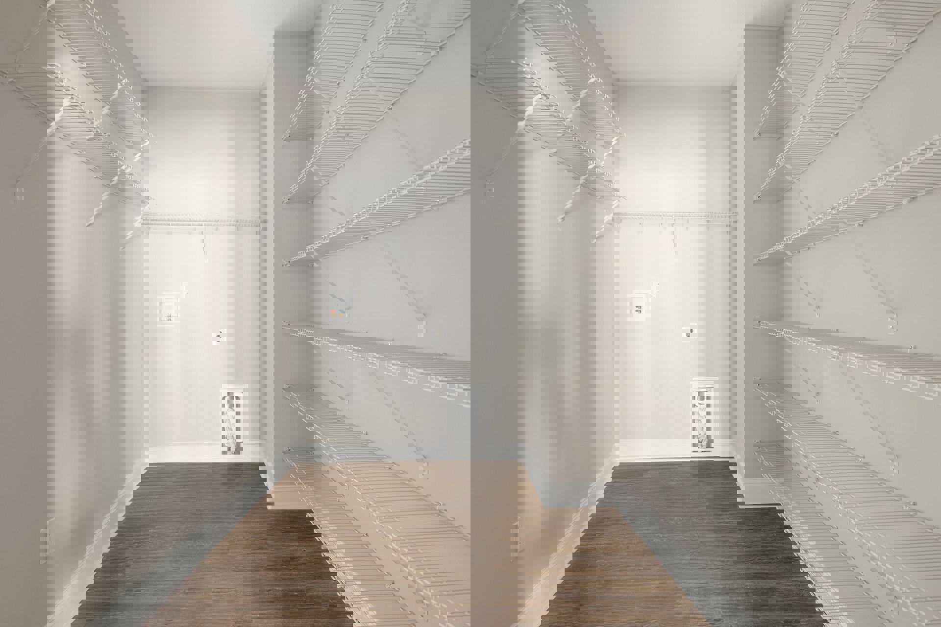 Spacious empty walk-in closet with white shelving, wood flooring, white walls, and a white ceiling