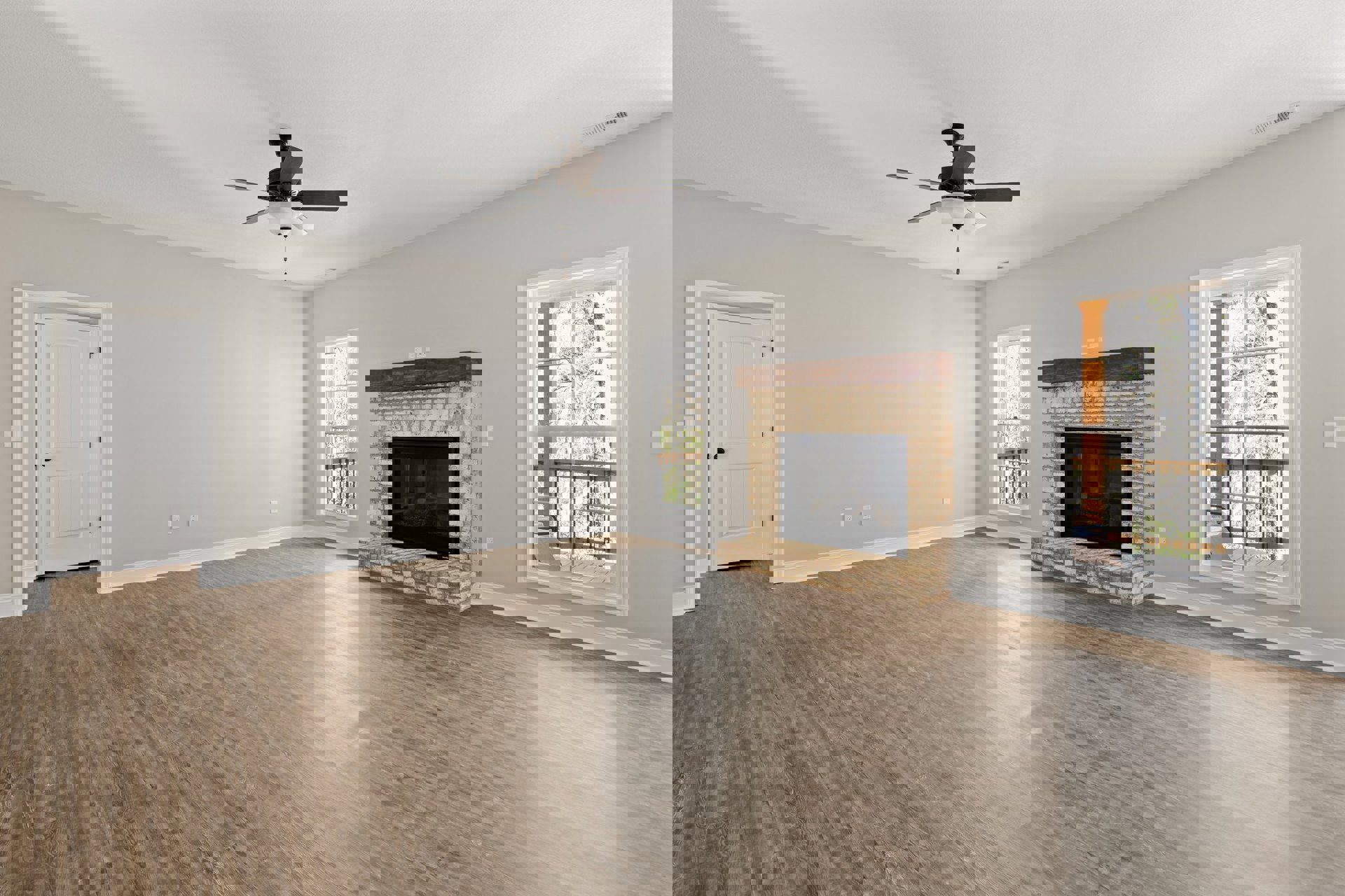 Hardwood floor living room featuring a fireplace with glass doors and a wood mantle, ceiling fan with light fixture, and white door with black handles