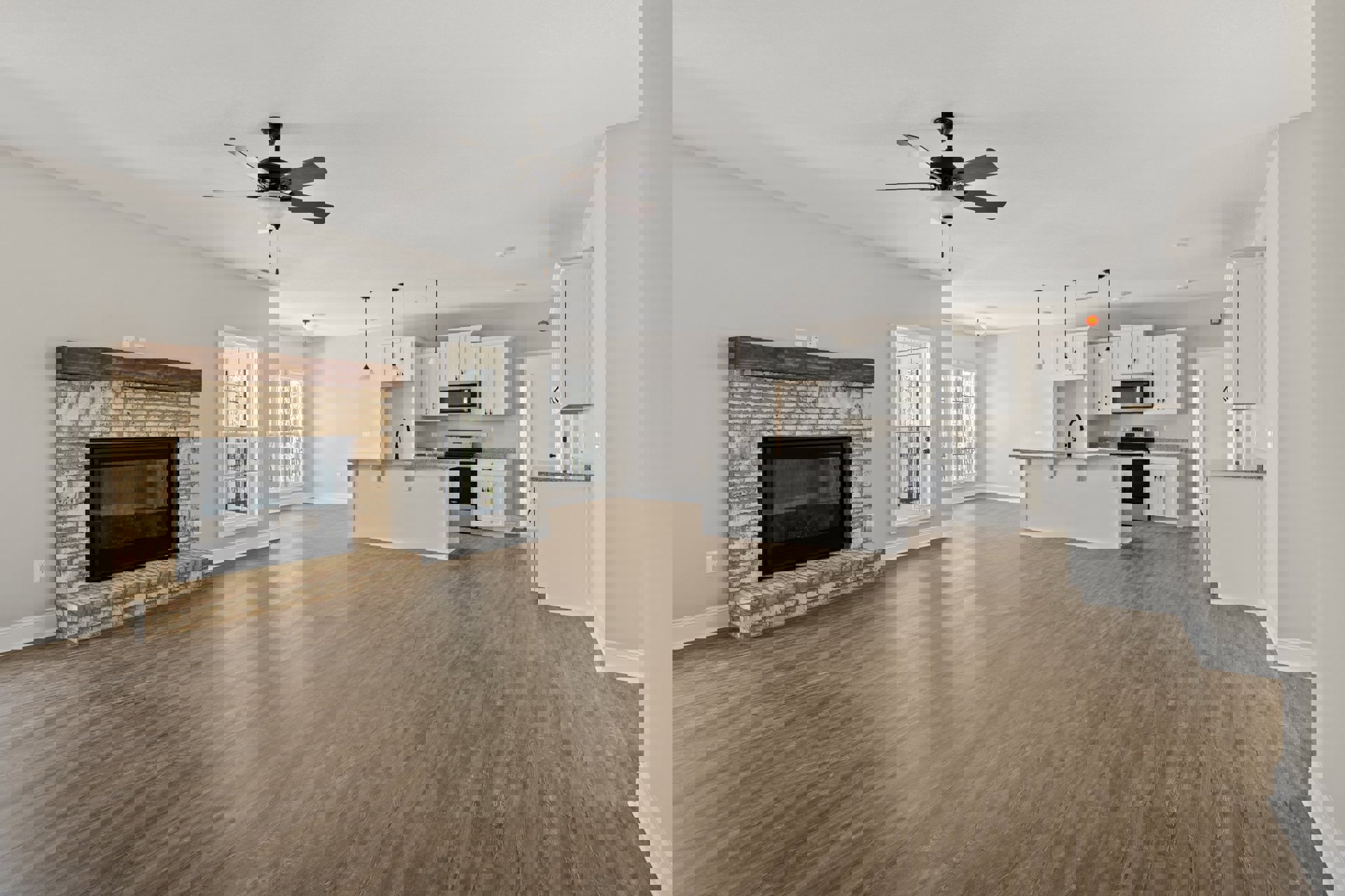 Living room with wood flooring, central fireplace with glass door, ceiling fan and light fixture, white door with glass panes, neutral walls