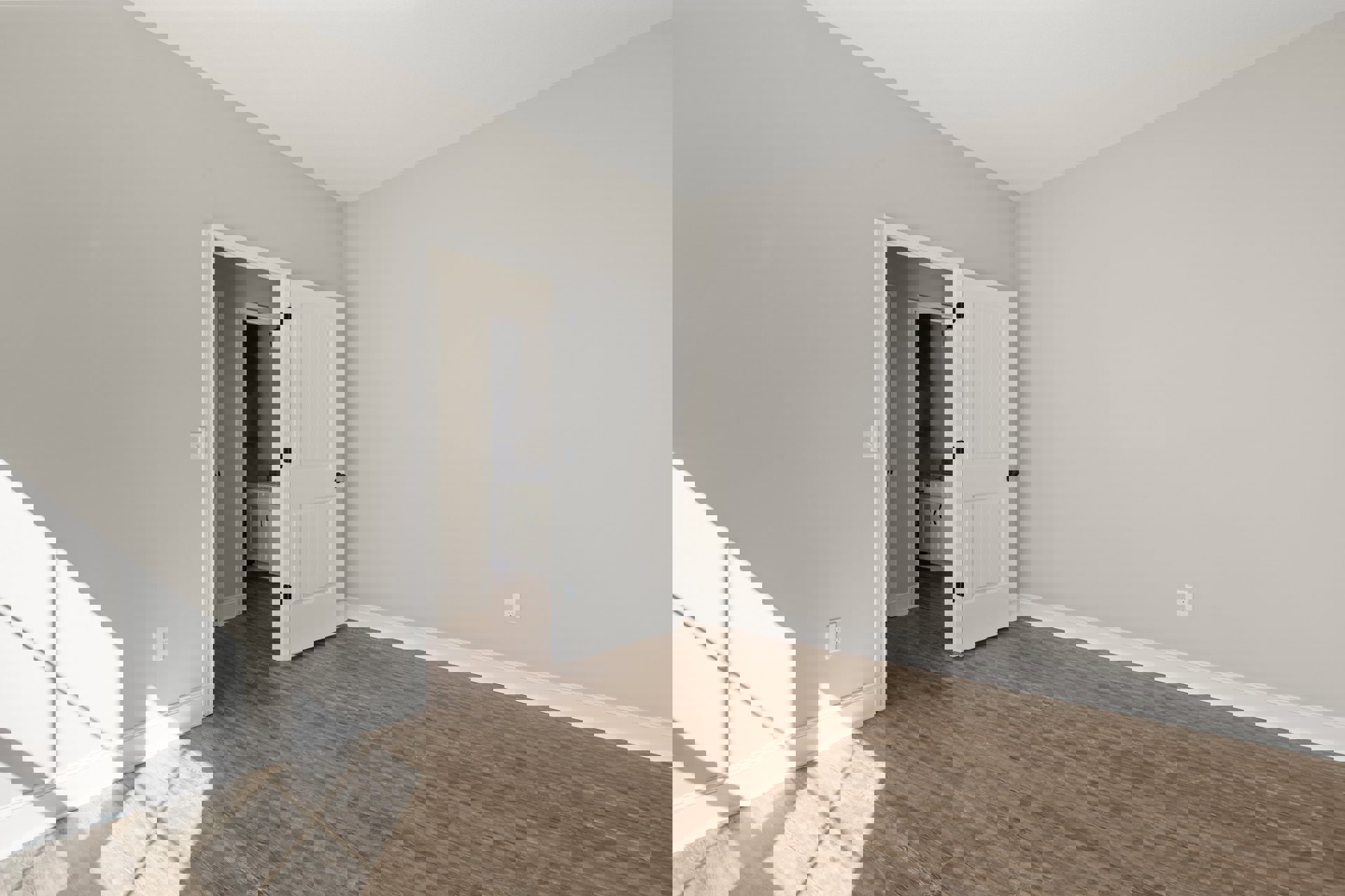 White paneled door with black knobs open onto wood laminate flooring, white walls, and a white cabinet with black handles; sunlight casts shadows near a window.