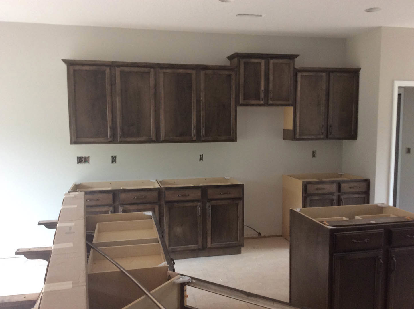 Modern kitchen featuring white shaker cabinets, quartz countertops with subtle black veining, stainless steel appliances, and a central island with built-in drawers.