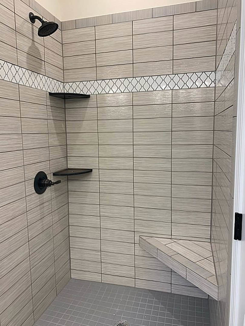 Tiled shower with built-in wall shelf and modern plumbing fixtures
