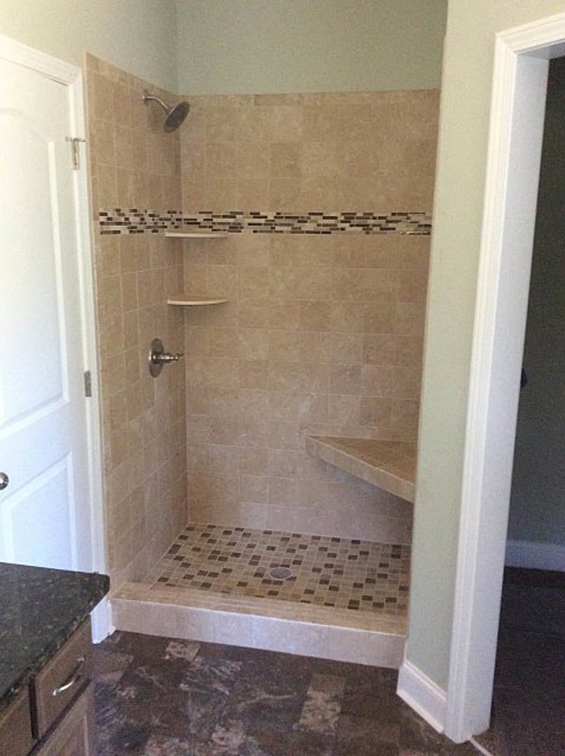 Walk-in shower featuring marble tile flooring, tiled walls, and modern plumbing fixtures