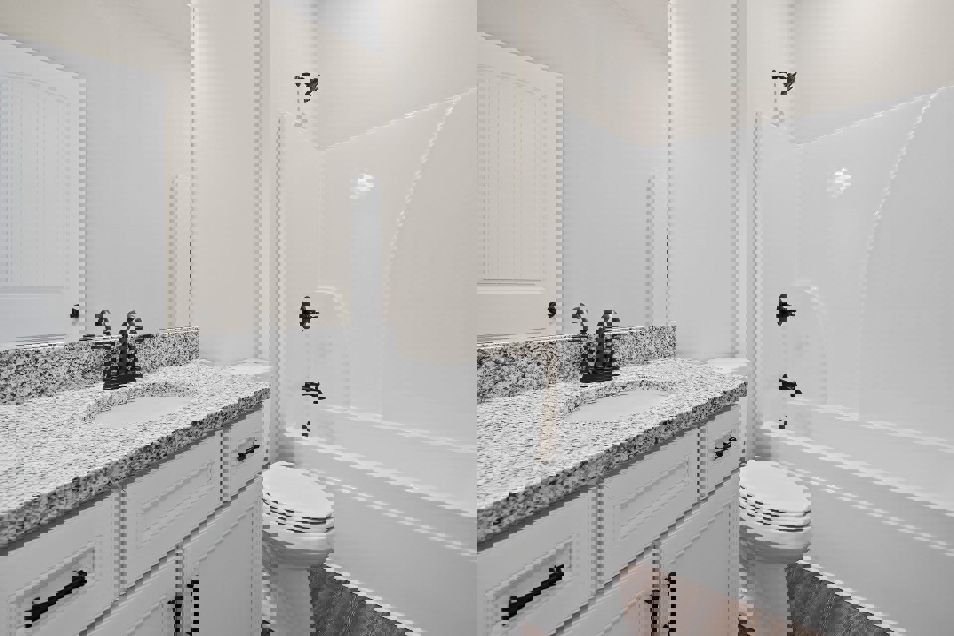 Bathroom with marble countertop, white bathtub, closed white toilet, white door with matching frame, black soap dispenser on countertop, chrome faucet, light tile flooring, neutral