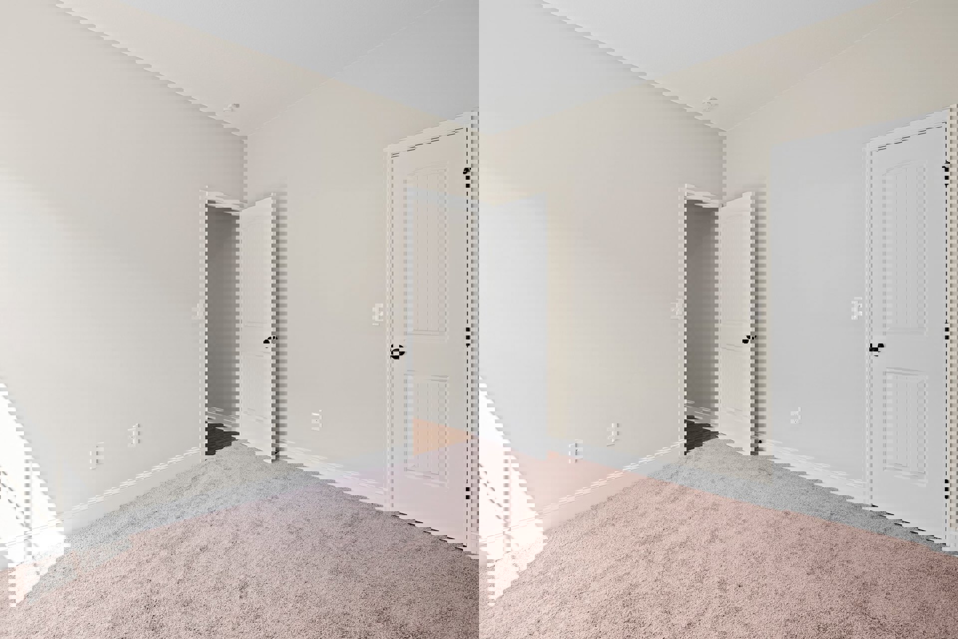 Pink carpeted room with two open white doors, black door knobs, white door frames, and white walls showing subtle shadows.