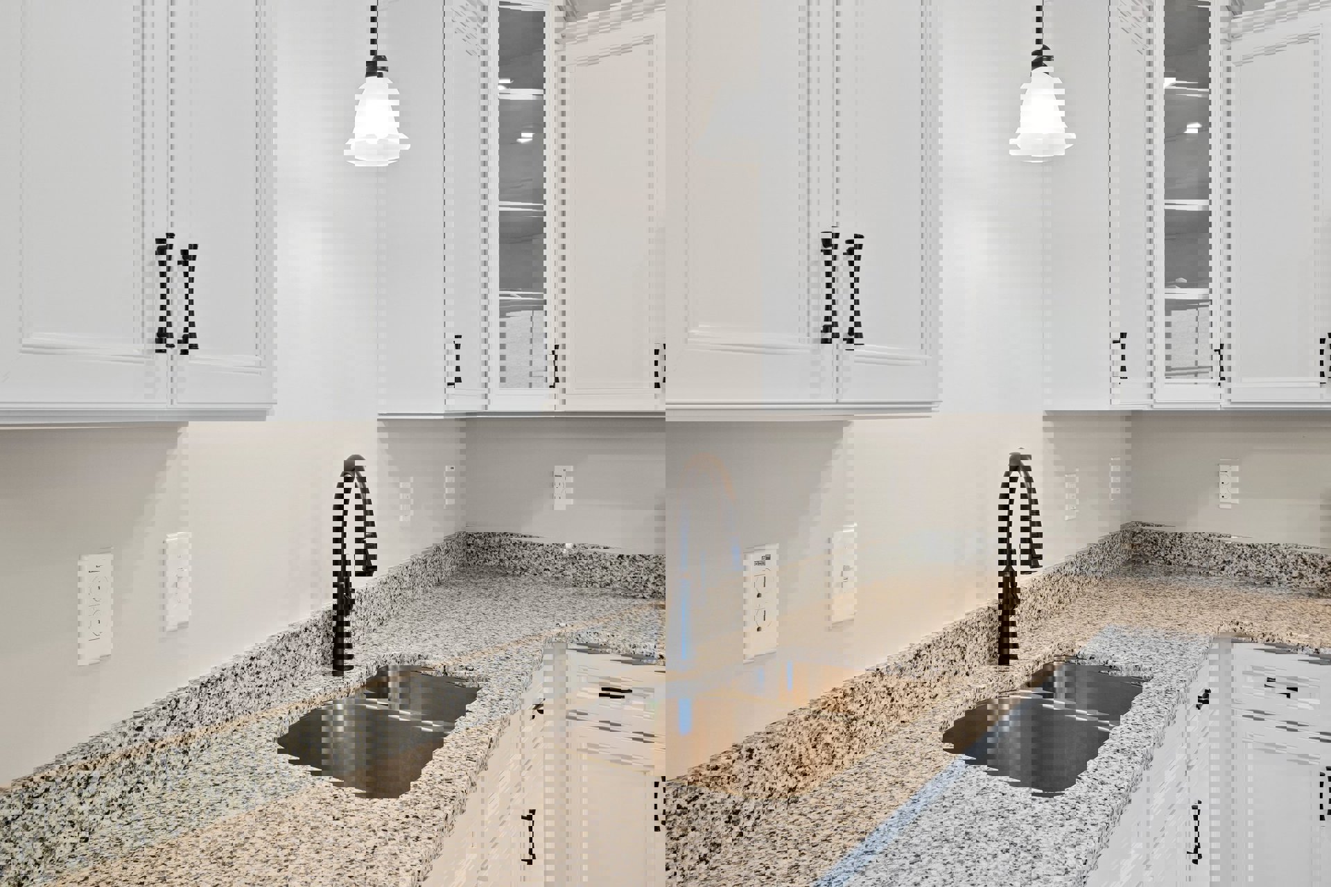 White kitchen with tile backsplash, white cabinets, stainless steel sink and faucet, quartz countertop, ceiling light fixture, white electrical outlet, and light switch on wall