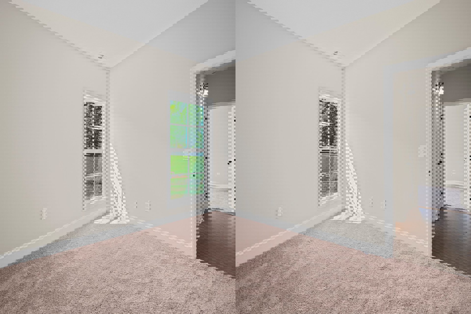 Bright room with beige carpet, white walls, large window overlooking green lawn and trees, wood trim, and baseboard molding