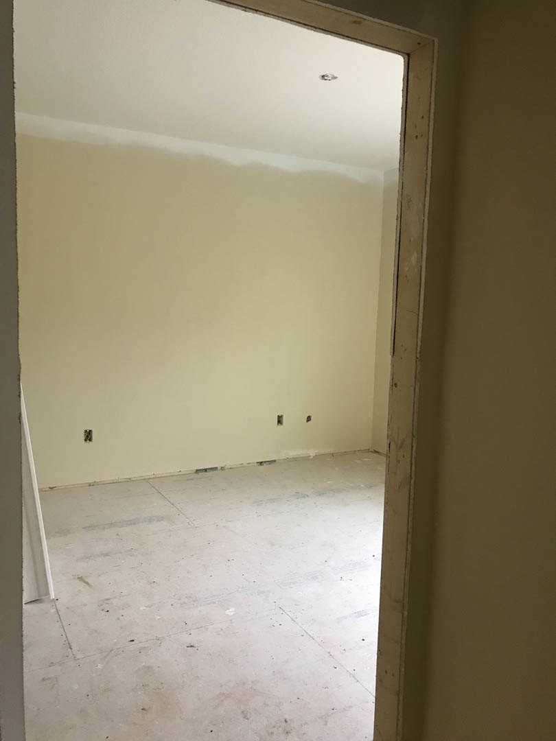 Modern room with smooth white plaster walls, seamless white flooring, and a matching white ceiling