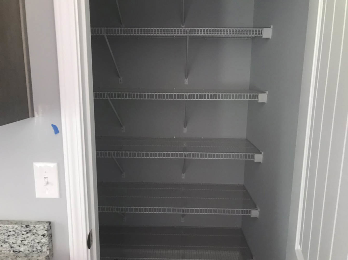 Walk-in closet with built-in white shelves and smooth painted walls