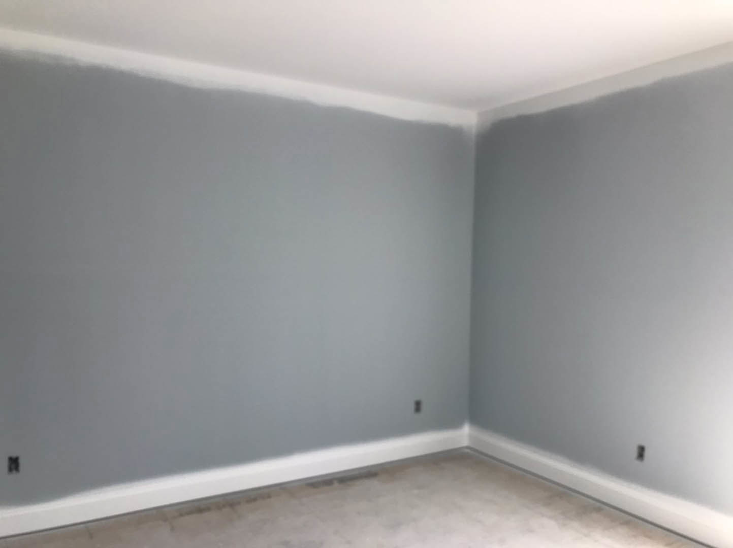 Modern interior room with smooth white plaster walls, seamless white flooring, and minimalist ceiling detailing