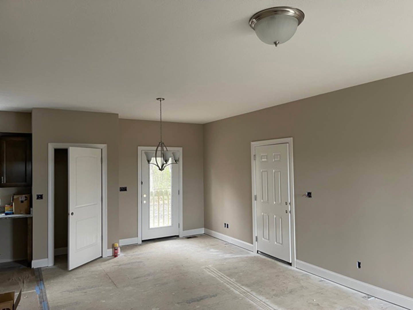 White paneled doors with glass inserts, smooth plaster walls, ceiling-mounted light fixture, hardwood flooring