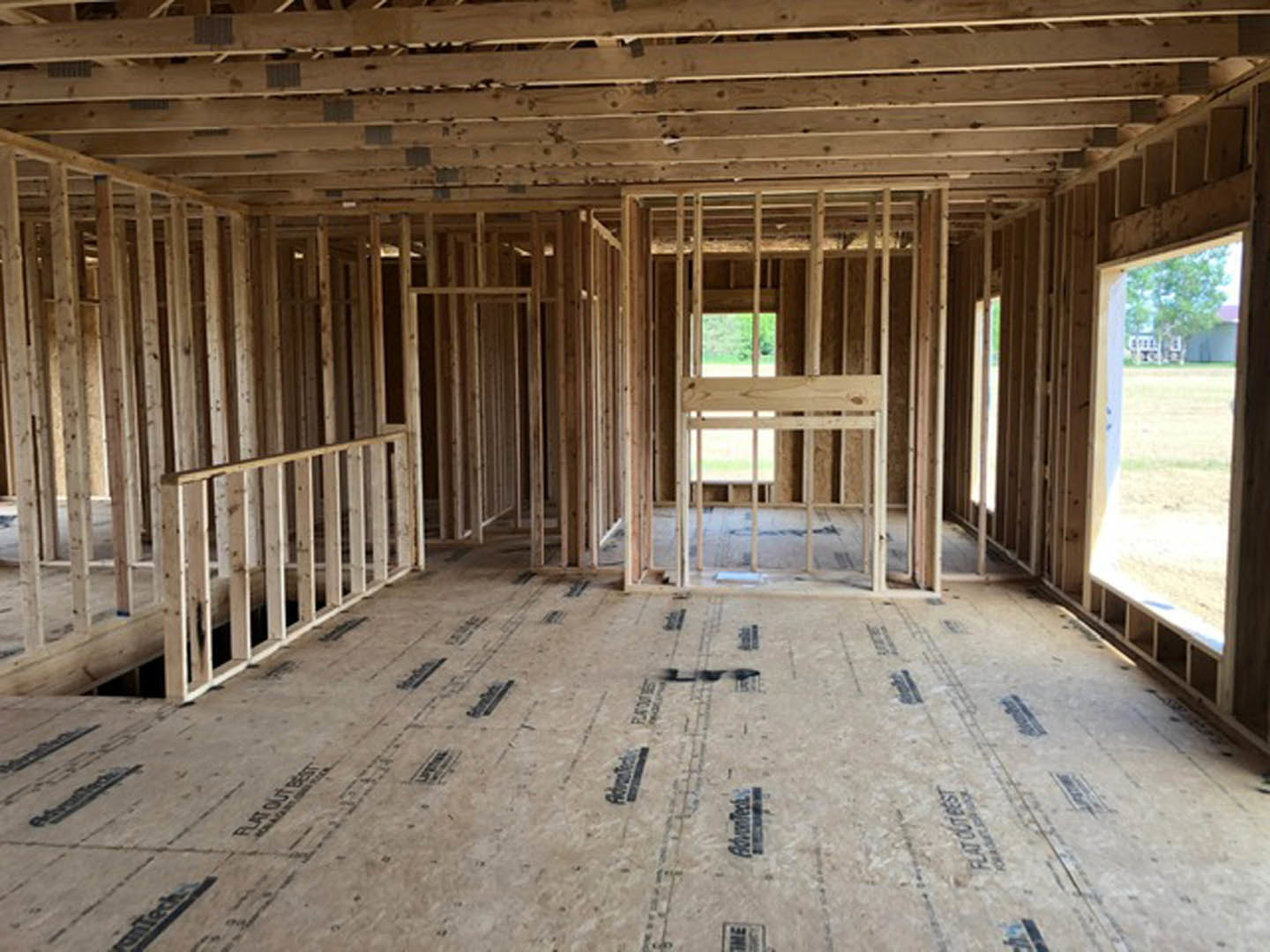 unfinished room with exposed wood framing, ceiling beams, and plank flooring
